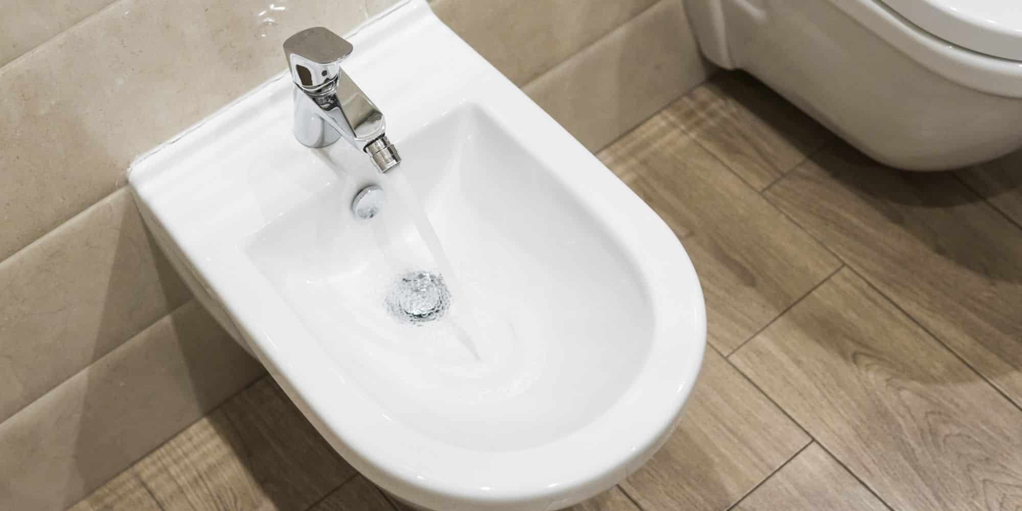 bidet ouvert avec de l'eau dans une salle de bain