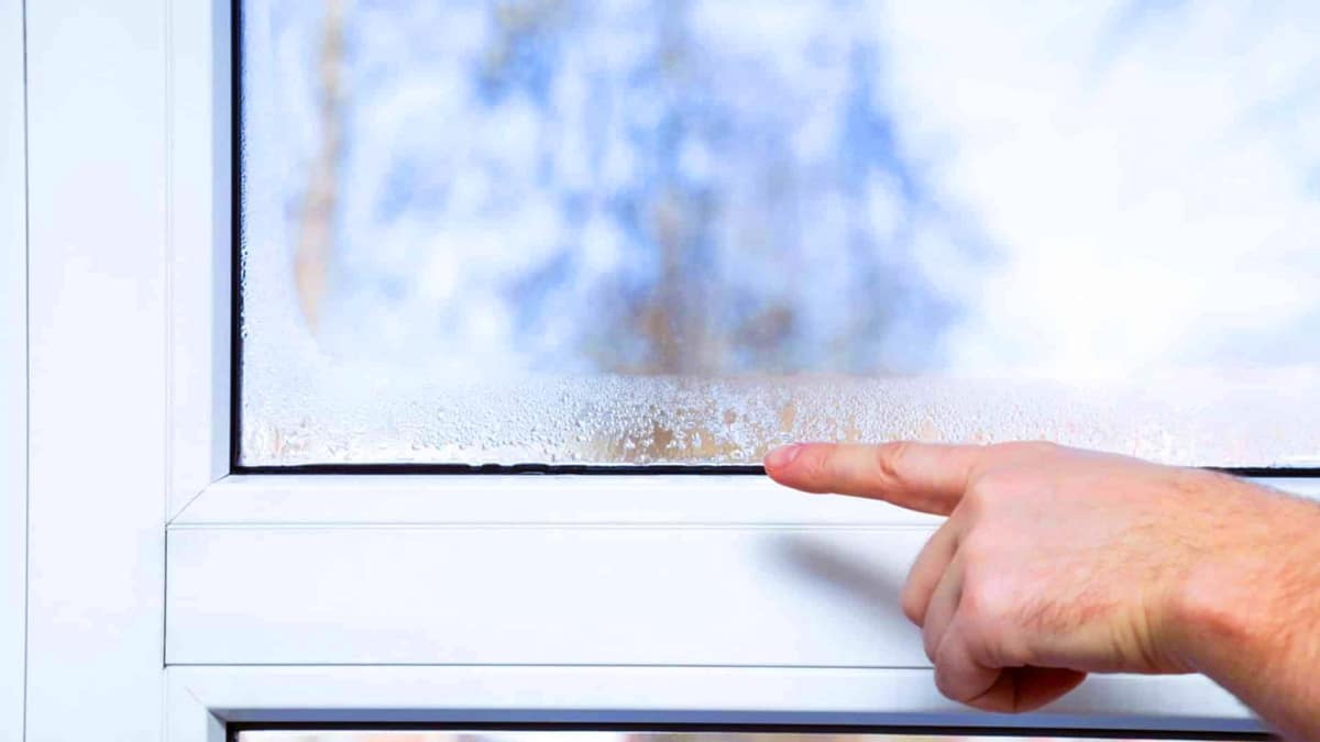 fenetre avec de la condensation pointé du doigt